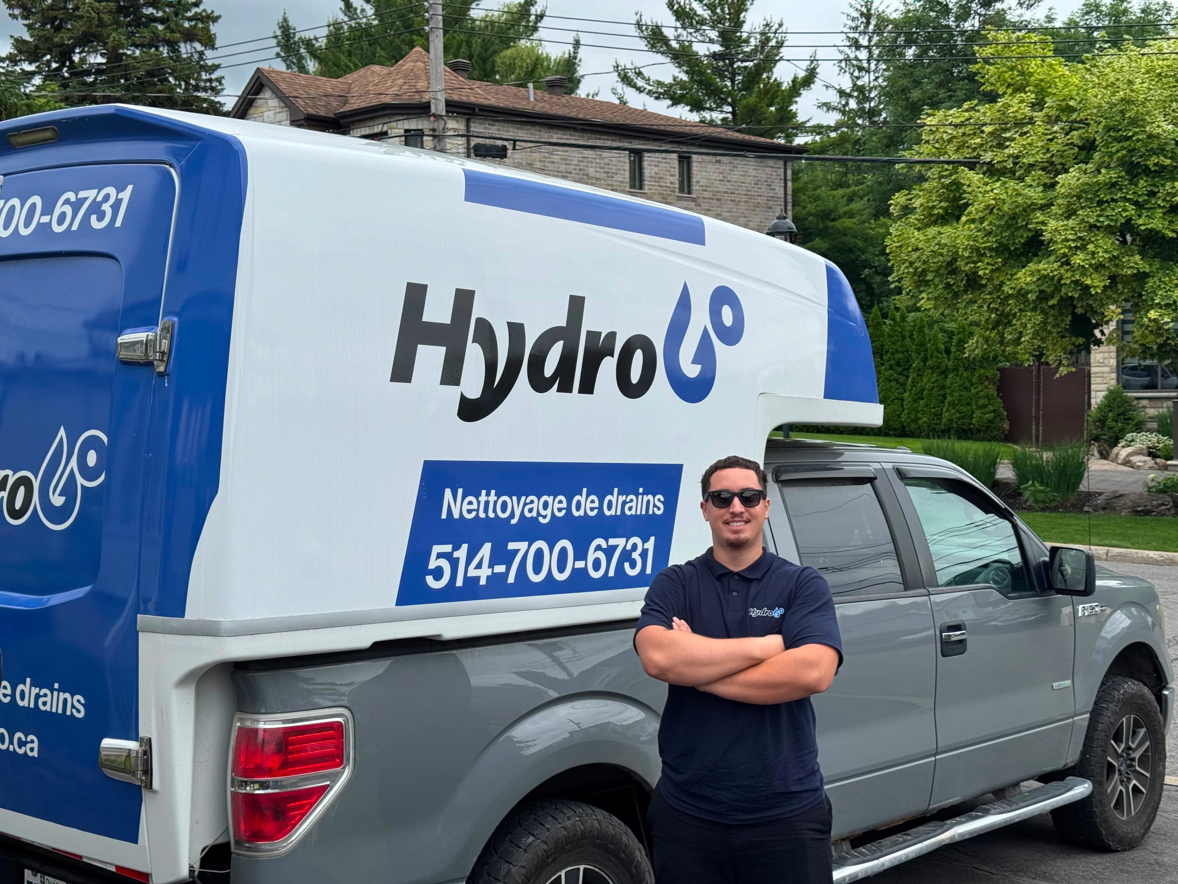 Yussef devant le camion HydroGo de nettoyage de drains à Montréal.